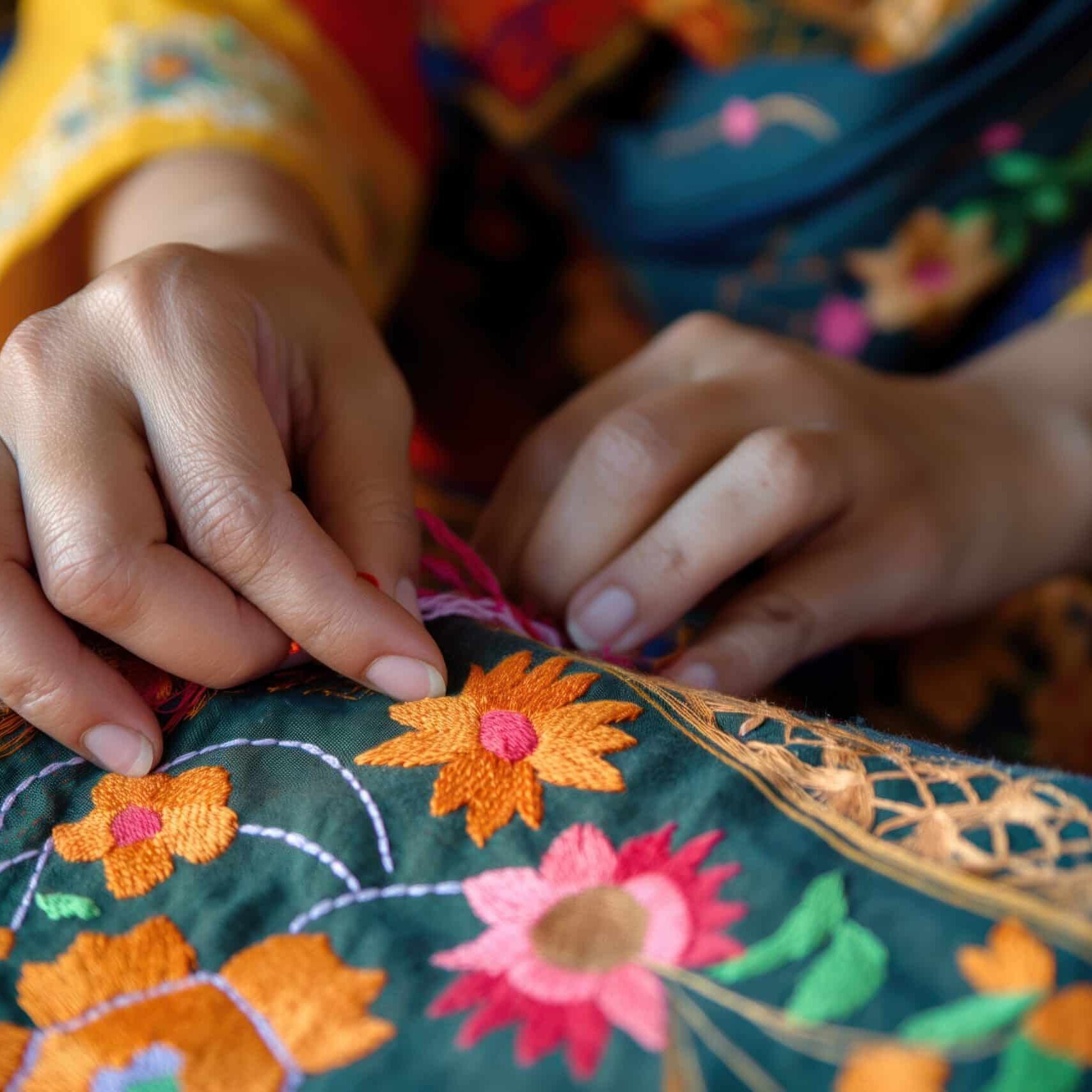woman sits at table with colorful fabrics